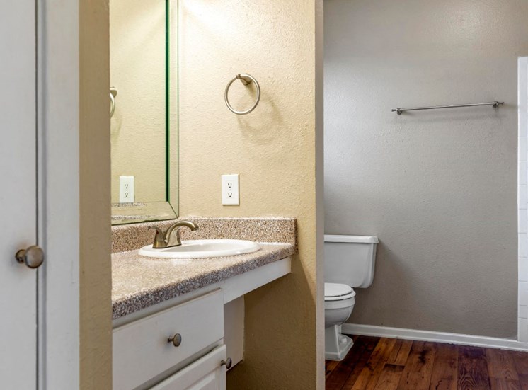 Bathroom with hardwood style flooring, towel bar, sink, and drawers for storage